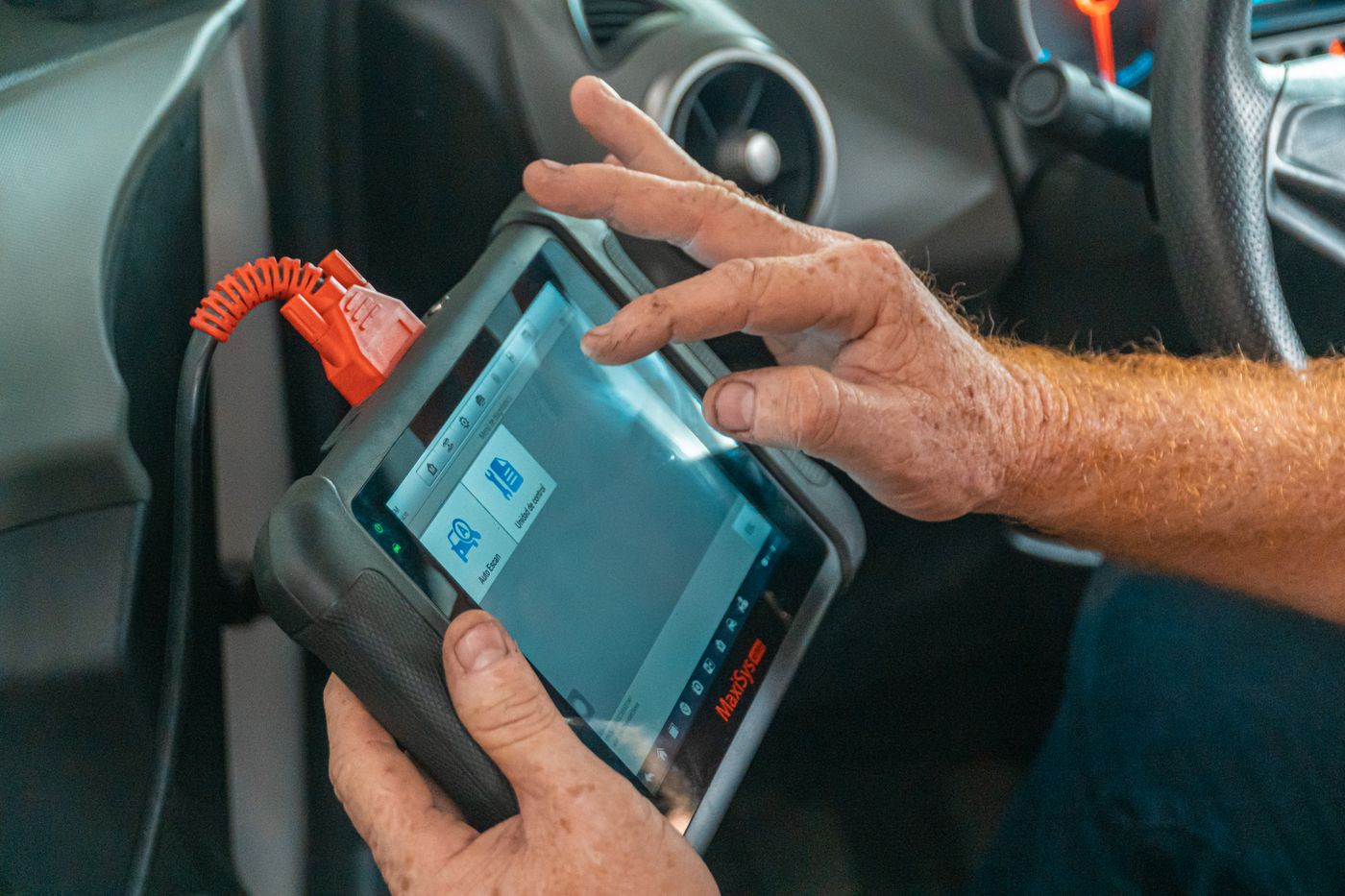 Technician running EPS torque sensor calibration on an OBD-II diagnostic tablet